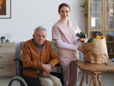 caretaker with groceries and senior man